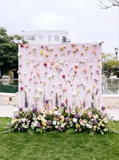 flowers are arranged on the side of a pink wall