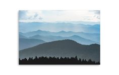 the blue mountains are covered in clouds and trees