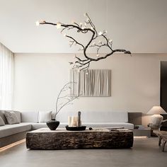 a living room filled with furniture and a tree branch