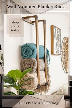 towels and blankets are hanging on the wall next to a potted plant in a living room