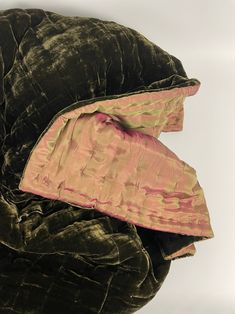 a large black and pink piece of clothing on top of a white surface