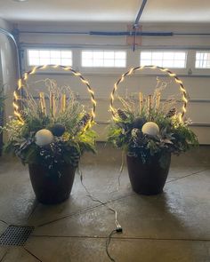 two large potted plants with lights in them