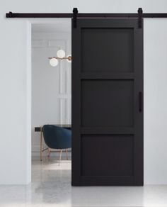 an open sliding door in a room with white walls and black hardware on the doors