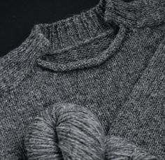 a ball of yarn sitting on top of a gray sweater