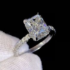 a diamond engagement ring on top of a white cloth