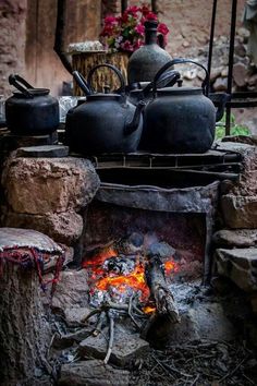 an outdoor stove with pots and pans on it