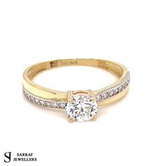 a yellow gold ring with diamonds on the sides and a single stone in the middle