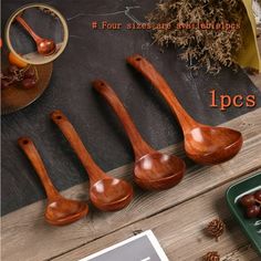 four wooden spoons sitting on top of a table next to an empty bowl and pine cones