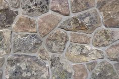 a stone wall that is made out of various types of rocks