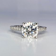 a diamond engagement ring with diamonds on the sides and an accent band around the band