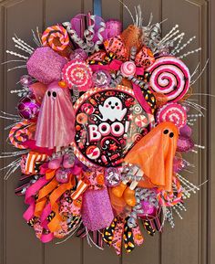 a wreath decorated with candy and decorations on the front door to celebrate boo's day