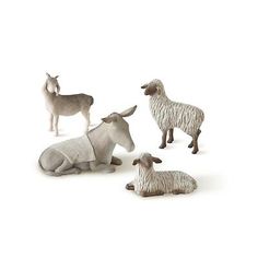 four figurines of sheep and goats on a white background