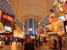 a man standing in the middle of a shopping mall with lots of lights on it