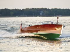 a small wooden speed boat speeding across the water