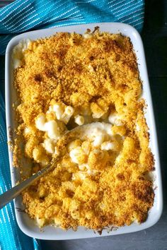 a casserole dish filled with macaroni and cheese on a blue towel