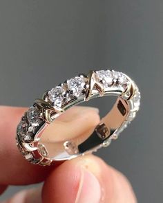 someone is holding a wedding ring with three stones on the inside and outside of it