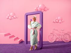 a woman standing in front of a mirror with balloons hanging from it's sides