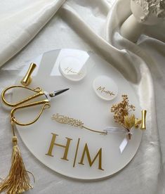 a white plate topped with gold writing on top of a table next to other items