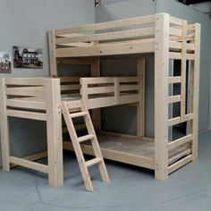 bunk beds made out of wood in a room with ladders on the bottom floor