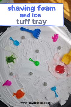 there is a cake with icing and plastic spoons on the plate that says shaving foam and ice tuff tray