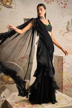 Black pre-draped saree with ruffle pleated border. Paired with sequin, bead, cutdana jewelled sleeveless net embroidered blouse.
Components: 2
Pattern: Embroidery
Type Of Work: Sequin, bead, cutdana
Neckline: Notched
Sleeve Type: Sleeveless
Fabric: Saree: Chiffon, Organza, Blouse: Net
Color: Black
Other Details: 
Back cut-out blouse
Ruffle pleated border
Occasion: Destination Wedding - Aza Fashions Drape Sari, Black Sari, Ridhi Mehra, Pink Anarkali, Net Blouses, Organza Blouse, Ruffle Saree, Embroidered Crop Tops, Drape Saree