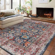 a living room filled with furniture and a rug on top of a hard wood floor