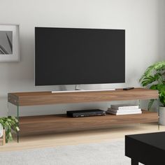 a flat screen tv sitting on top of a wooden entertainment center in a living room