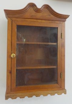 an old fashioned wooden shelf with glass doors