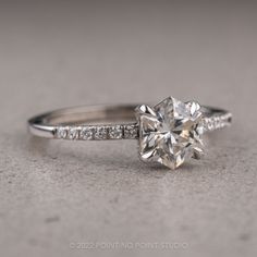 an engagement ring with a diamond on the side and pave set diamonds around it