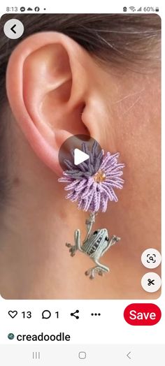 an earring with a frog on it and a flower attached to the back of it