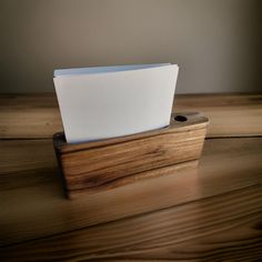 a wooden desk with a laptop computer on it's side and a mouse pad in the middle