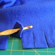 a close up of a blue cloth with a wooden spoon in the middle and a piece of fabric on top