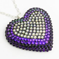 Explore the depths of outer space with this colorway, featuring over three hundred hand placed dark purple velvet and color-changing crystals that glow like interstellar radiation. DETAILS Heart Charm: 2” wide Chain: 18” chain + 2" extender Made to order. Please allow 1-2 weeks for delivery. SIZE CHART Crystal Heart Pendant Necklace For Party, Party Crystal Heart Pendant Necklace, Glamorous Crystal Necklace As A Gift, Heart-shaped Purple Jewelry For Party, Crystal Heart Cut Jewelry With Heart Beads, Dazzling Crystal Rhinestone Necklaces For Gifts, Heart Shaped Purple Jewelry For Party, Crystal Jewelry With Heart Beads And Heart Cut, Glamorous Heart-shaped Crystal Necklaces