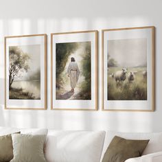 three framed pictures hang on the wall above a couch in a living room with white furniture