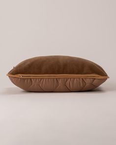 a brown pillow sitting on top of a white table