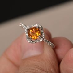 This is a gorgeous handmade creation. Its beauty is its simplicity & Elegance. The 6*6mm round cut natural citrine is crafted in solid sterling silver and with rhodium plated. It is available to customized, if you have any mind, just let me know, we will discuss with it. All item is sent in a beautiful gift box You can realize more lovely stuff clicking the link https://www.etsy.com/shop/knightjewelry?refshopsection_shophome_leftnav Please leave the correct address and you PHONE NUMBER for d Orange Sapphire Round Ring, Orange Round Yellow Sapphire Jewelry, Fine Jewelry Yellow Topaz Ring With Halo Setting, Yellow Topaz Ring With Halo Setting, Yellow Topaz Halo Ring Fine Jewelry, Yellow Sapphire Ring With Center Stone, Round Yellow Sapphire Ring With Accent Stones, Elegant Orange Yellow Sapphire Rings, Orange Diamond Jewelry With Halo Setting