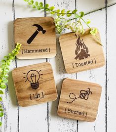 four wooden coasters with different types of symbols on them and flowers in the background