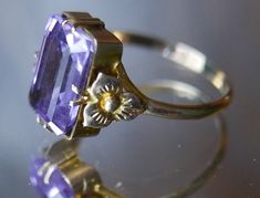 Antique Victorian delicate gold ring with dazzling emerald cut amethyst gemstone in elegant basket setting with belle epoch floral motifs on shank. Photographs cannot do justice to this beautiful piece.  Stamped as shown in photographs. Excellent vintage condition. Ring size: Adjustable, US 7 / 17.5 mm Gemstone length: 1.4 cm ☞ Please view my shipping and sales policies and ✎ Contact me with questions prior to purchase...all sales are final. http://www.etsy.com/shop/Andeebird/policy Baguette Cut Amethyst Ring For Formal Occasions, Classic Yellow Gold Rectangular Amethyst Ring, Hallmarked Emerald Cut Amethyst Ring For Formal Occasions, Formal Amethyst Ring With Diamond Cut, Rectangular Amethyst Ring For Formal Events, Rectangular Amethyst Ring For Formal Occasions, Elegant Purple Amethyst Baguette Cut Ring, Elegant Rectangular Amethyst Ring In Yellow Gold, Elegant Purple Baguette Cut Amethyst Ring