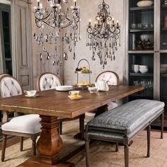 a dining room table and chairs with chandelier hanging from the ceiling above it