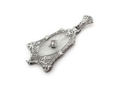 Genuine Art Deco period (circa 1920s-30s) 14k white gold filigree pendant with camphor glass panel and a 2.7mm diamond accent. Lovely bell-like shape and fine filigree work. All in excellent condition.This would be a stunning bridal pendant or a pendant for any special occasion. The pendant has no marks but tests as 14k gold. Measurements: 1 1/2" high x 3/4" wide. Weight: 2.5g. Note: The14k karat white gold chain (14.25 inches long) may be added to the purchase for an additional $115. Note: The14k karat white gold chain (14.25 inches long) may be added to the purchase for an additional $115. NEC_0008.24 FREE DOMESTIC STANDARD SHIPPING Another Sky Vintage Home Page https://www.etsy.com/shop/AnotherSkyVintageLLC?ref=hdr_shop_menu PA residents will have 6% sales tax added where applicable. Ot Art Deco Pendant Jewelry With Single Cut Diamonds, Art Deco Single Cut Diamond Pendant Jewelry, Art Deco Single Cut Diamond Pendant, Art Deco Style Single Cut Diamond Pendant, Antique Diamond White Pendant Jewelry, Vintage Diamond White Pendant Jewelry, Vintage Diamond White Filigree Jewelry, Antique Diamond Intaglio Jewelry, Vintage White Gold Filigree Jewelry