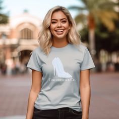 a woman wearing a grey t - shirt with the word cinderella co printed on it