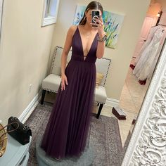 a woman in a purple dress taking a selfie