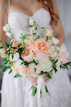 a bridal holding a bouquet of white and peach flowers