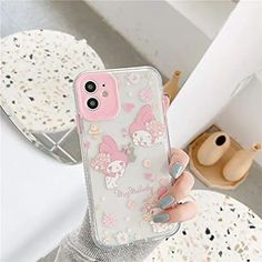 a girl holding up her phone case with pink flowers and bunny ears on the back