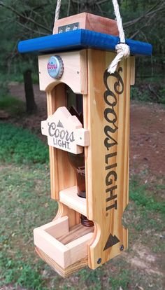 a wooden bird feeder hanging from a rope