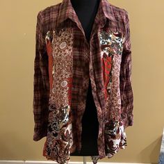 a mannequin wearing a red and black shirt with paisley designs on it's chest