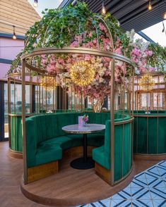 a green booth with pink flowers on the ceiling