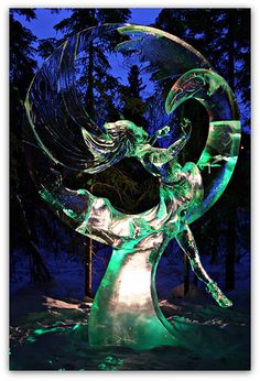 a glass sculpture in the shape of a woman holding a bird on her back, surrounded by snow and trees at night