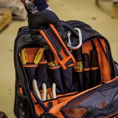 an orange and black bag filled with lots of different tools in it's pocket