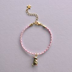 a bracelet with a teddy bear on it and a star charm hanging from the end